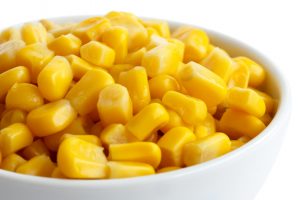 Bowl of tinned sweetcorn isolated on white. Detail.