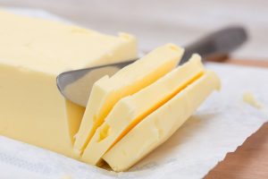 fresh butter in bar form on a table and a knife